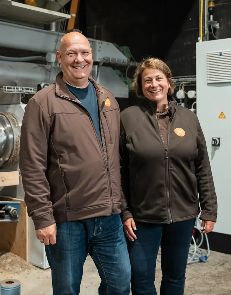 Hartwig Taege und Kristin Röschmann stehend lachend nebeneinander in der Produktionshalle von Röschmann